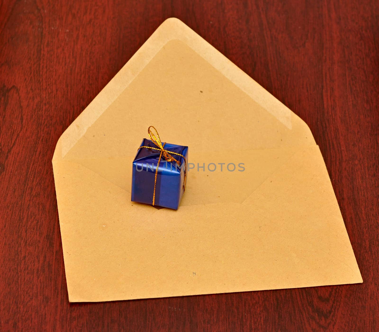gift box with envelope on wood background by inxti