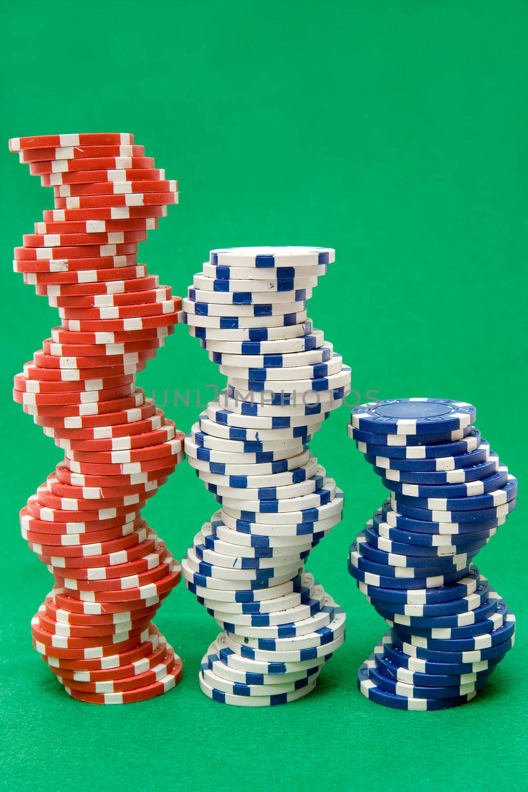 Stacked jetons isolated on green poker table felt.