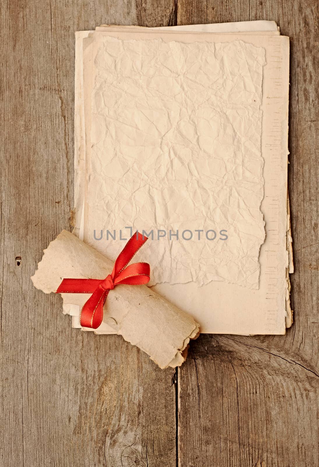 old paper sheets with old paper roll on wooden background