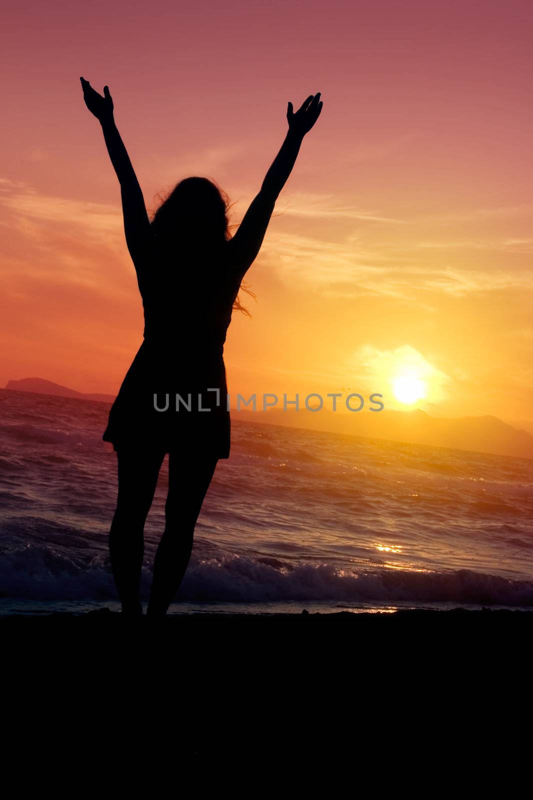 Silhouette of a young girl enjoying the golden sunset.