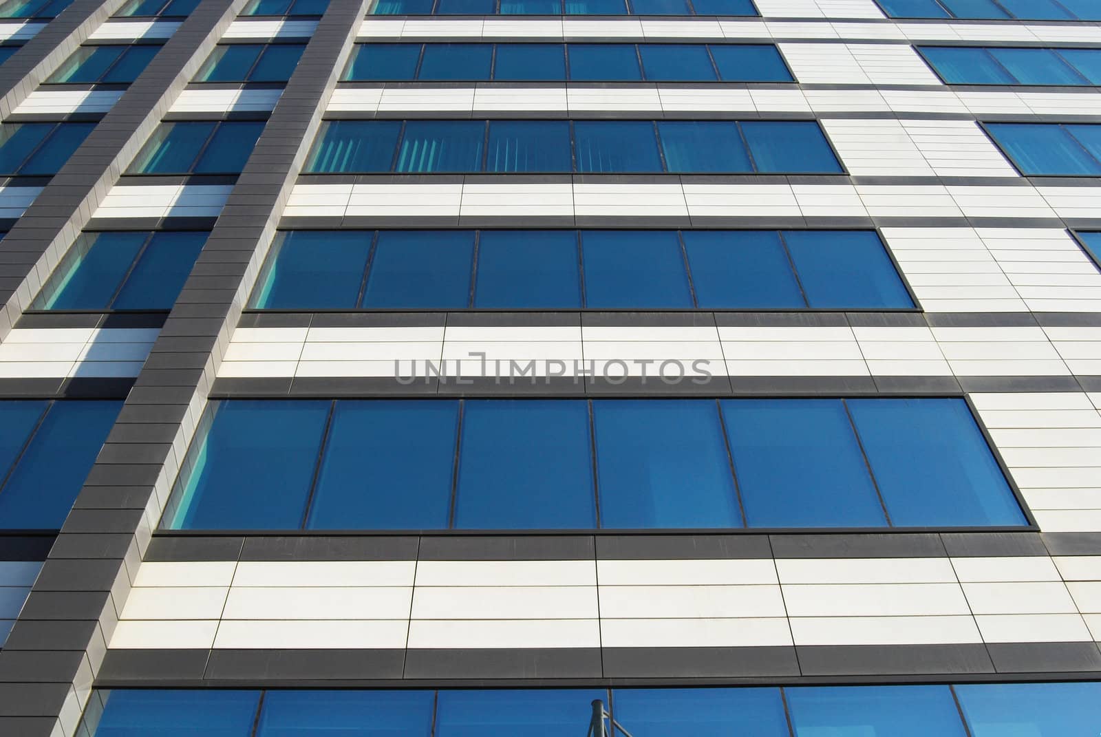 Office building wall down-up view with blue glass windows