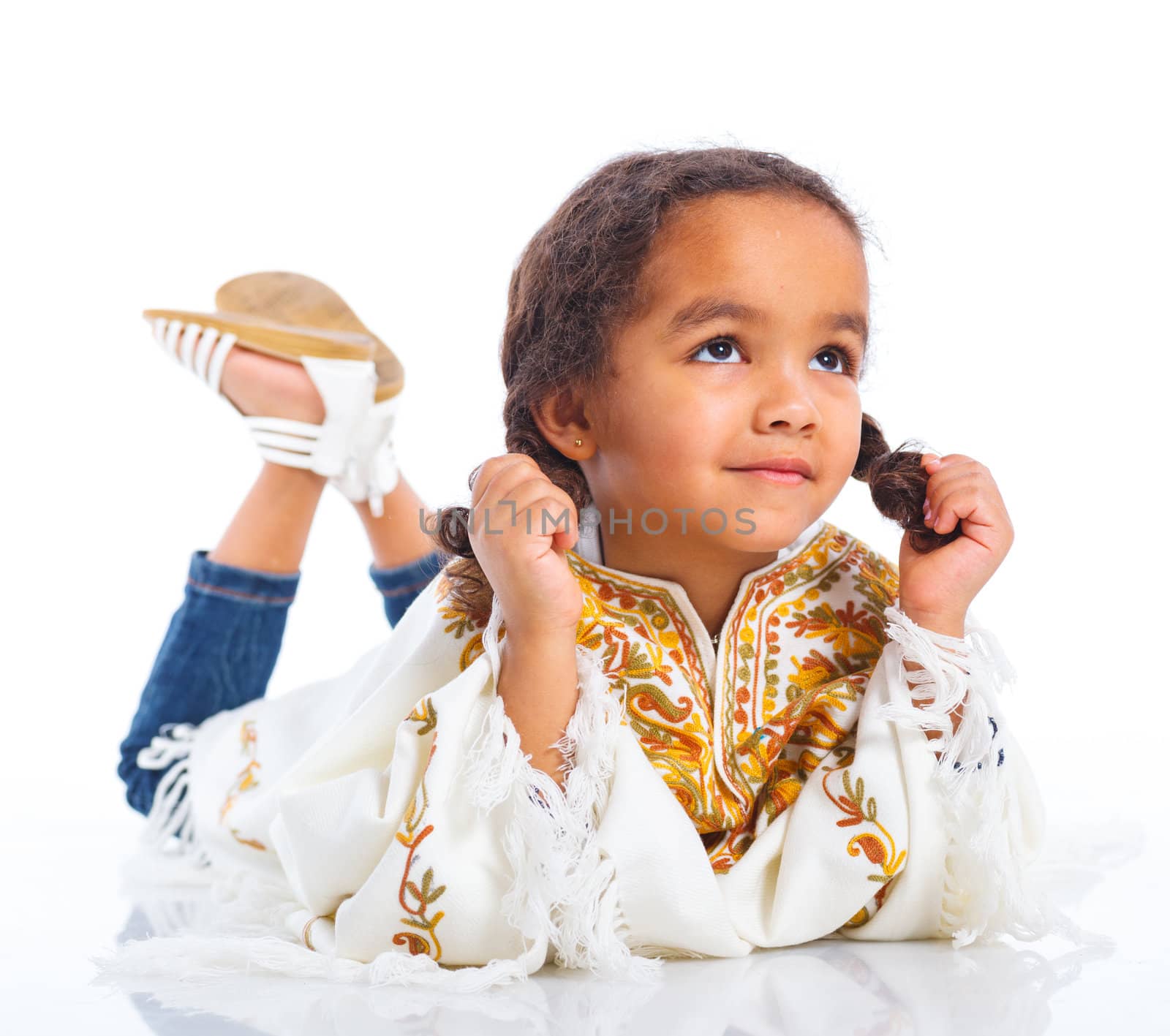 Cute little mulatto girl lying and smiling. Isolated on white background