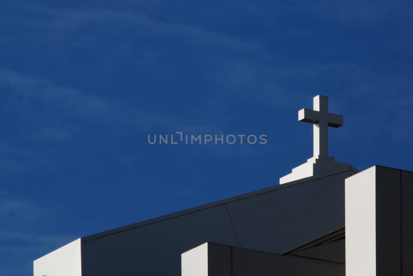Cross of modern catholic church on sky background