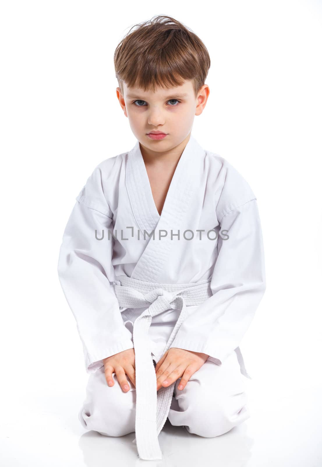 Aikido boy recreation position in white kimono isolated on white