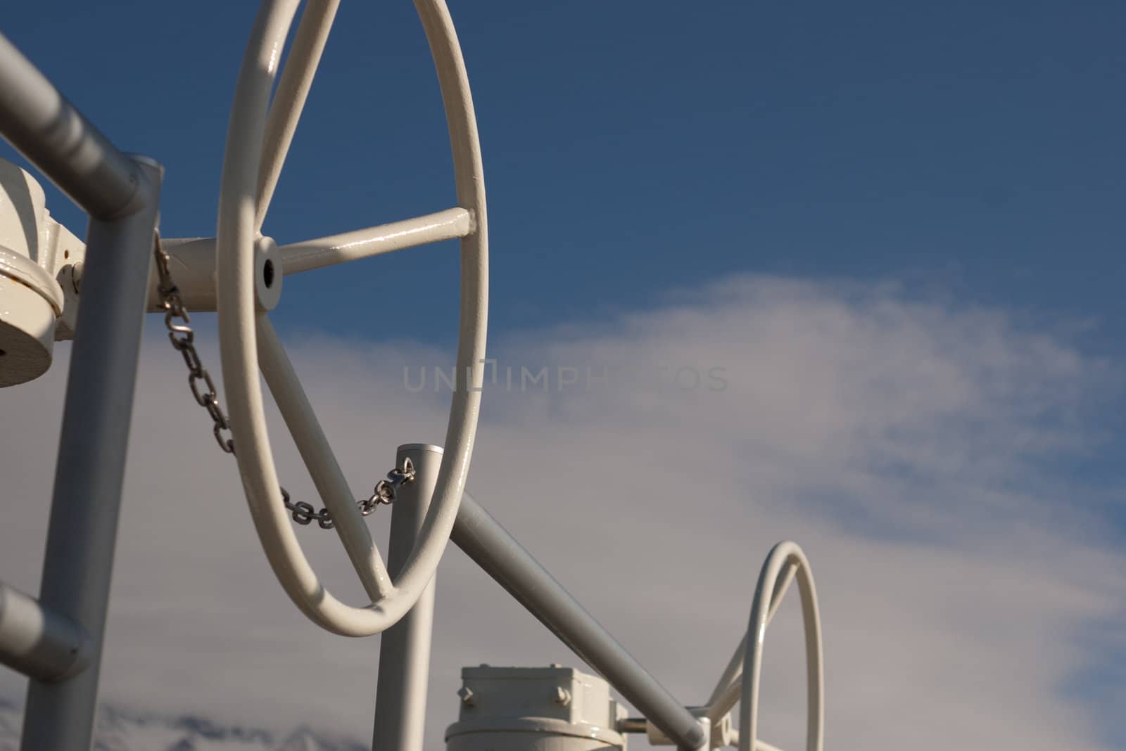 wheels for opening and closing valves against blue and cloudy sky