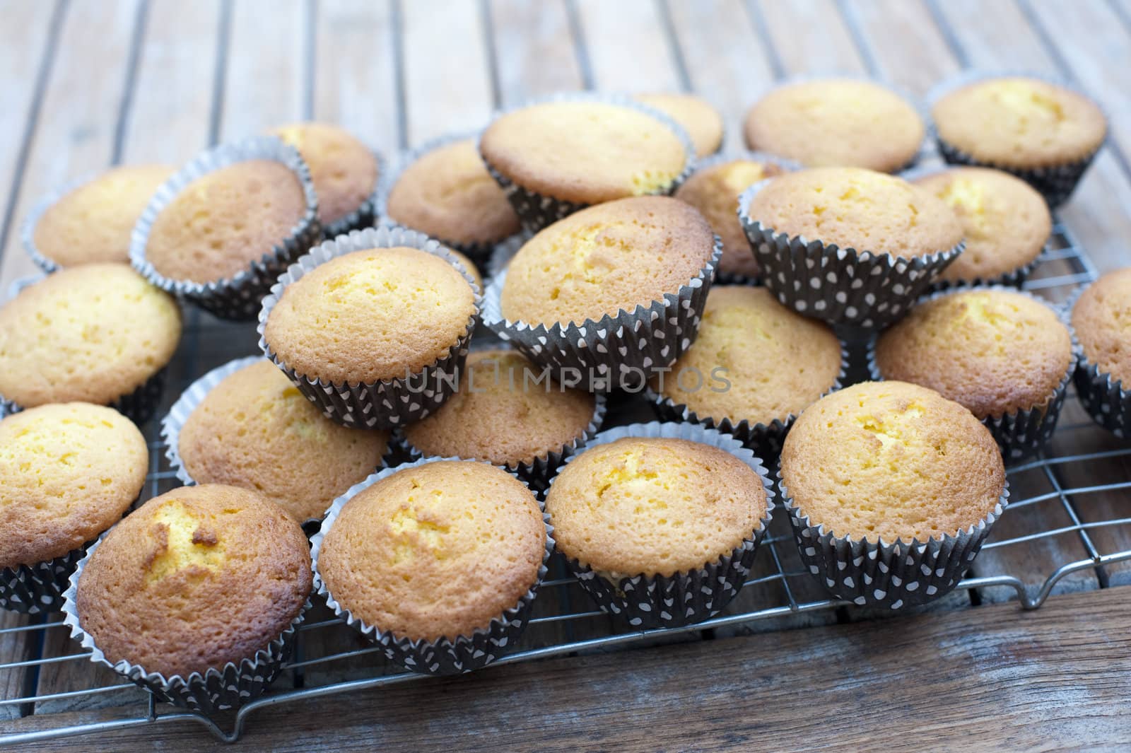 pile of home baked party cakes cooling on a wire tray