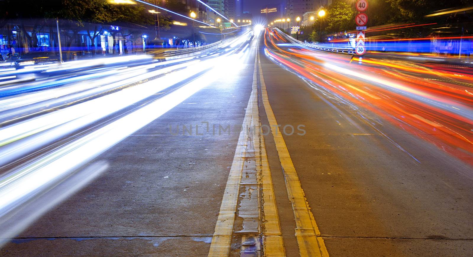 High speed traffic and blurred light trails in downtown night-scape by jackq