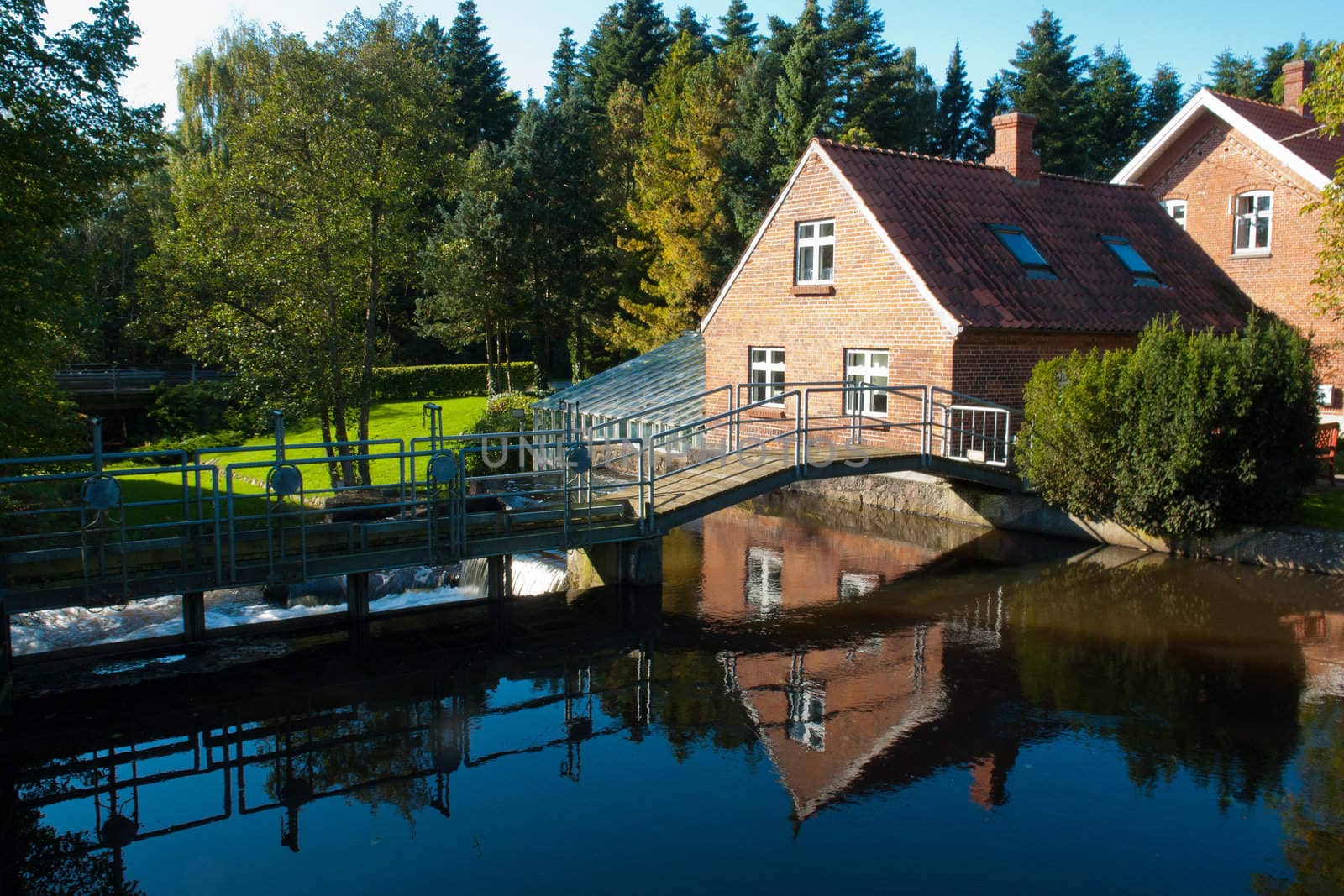 Beautiful traditional countryside style house reflected in a lake Denmark