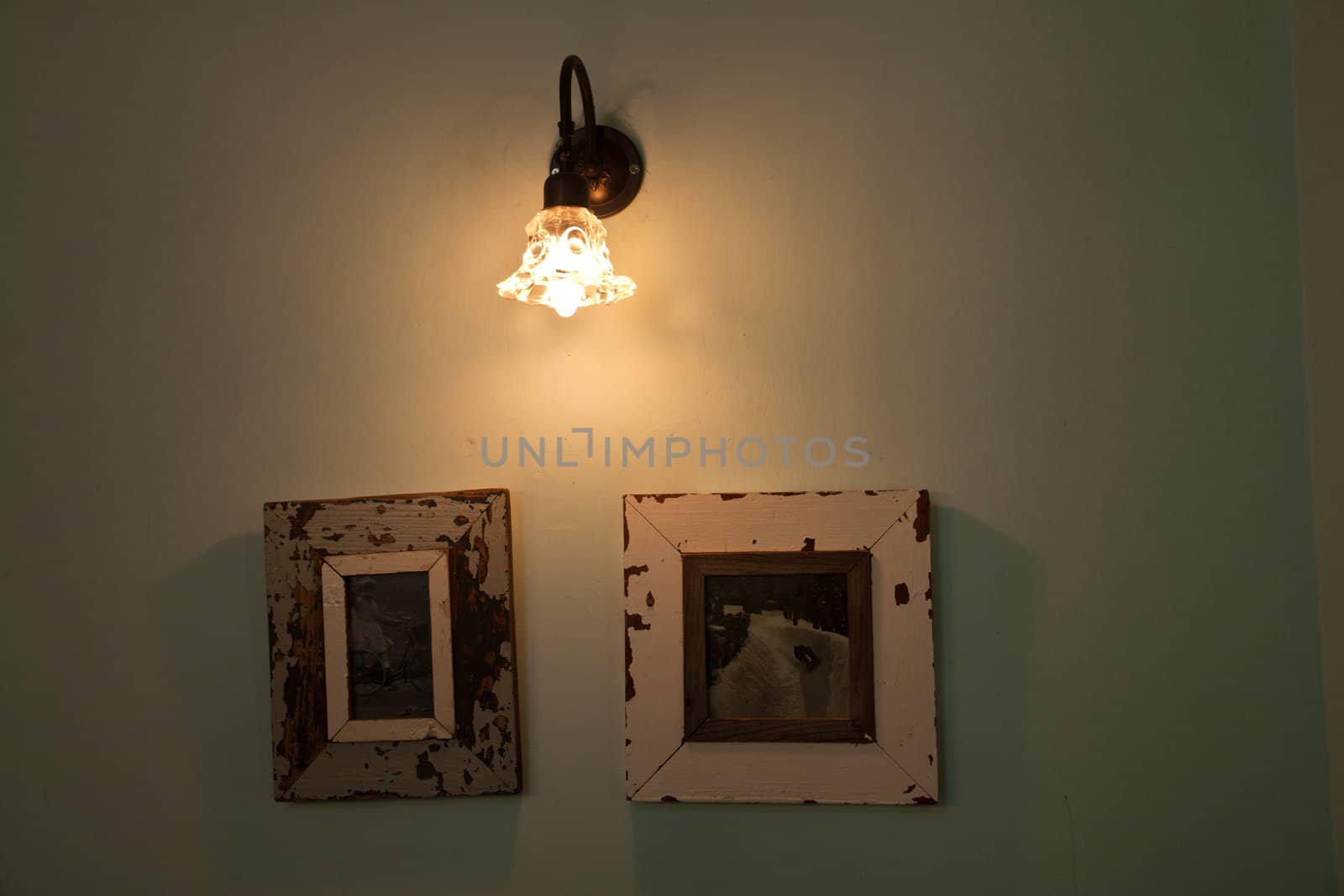 Vintage elegant wall lamp hanged above antique pictures