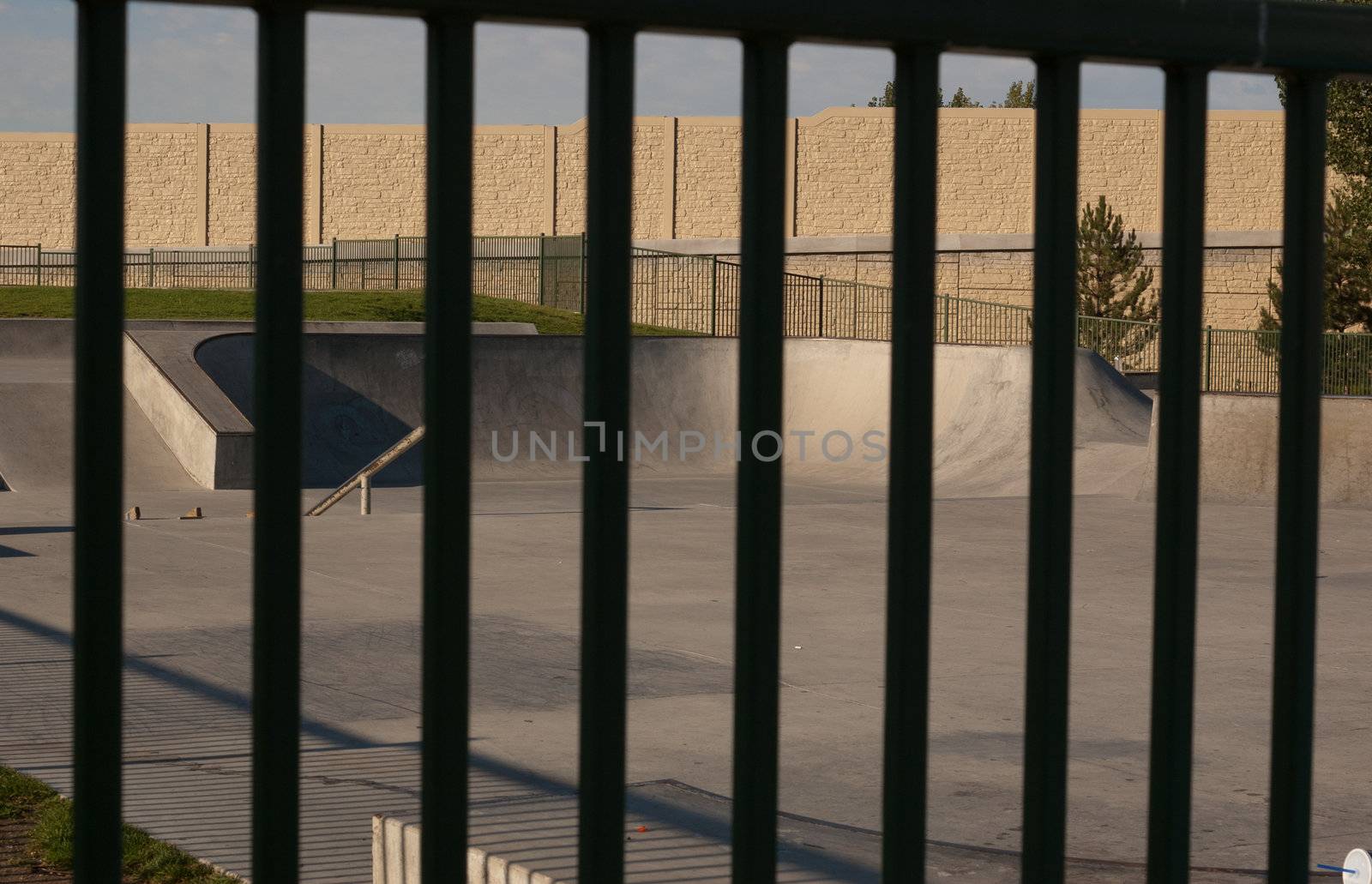 looking at deserted skate park through black fence