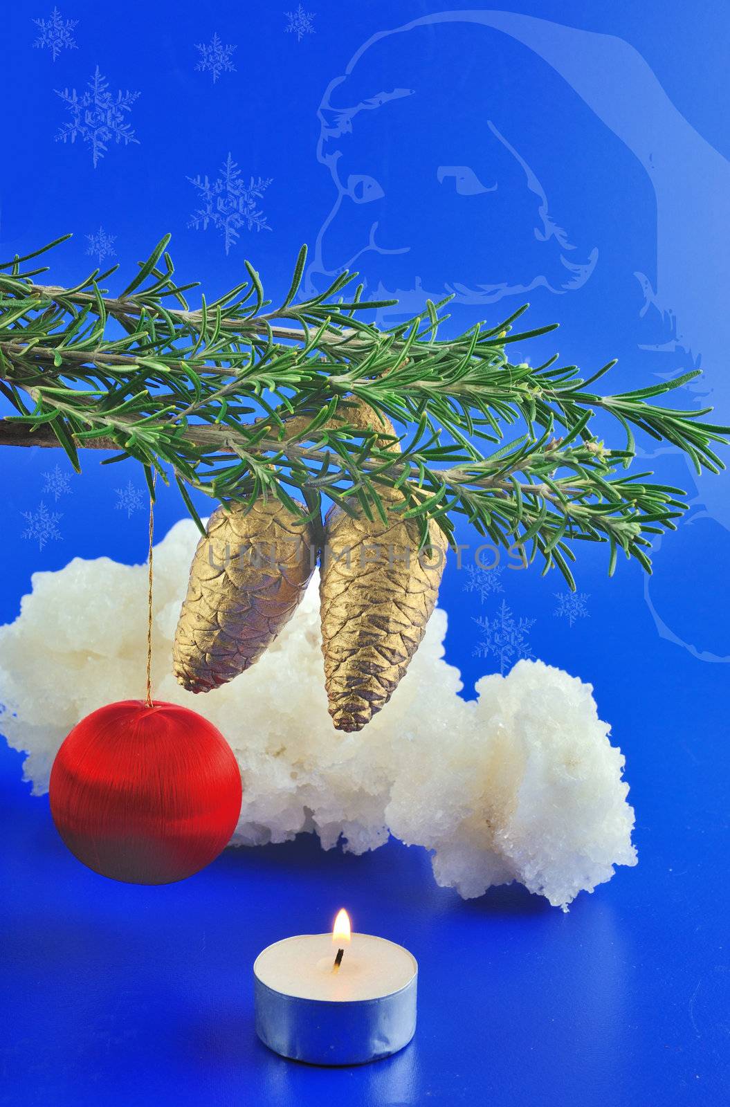 Red balls, cone spruce, ice and sprigs to decorate and candles burning for Christmas, against a blue background