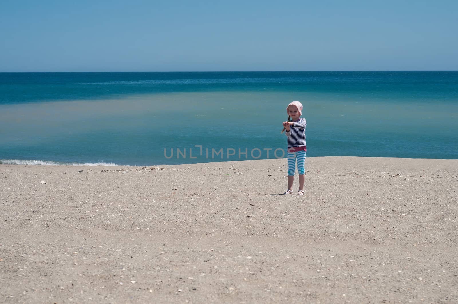 Small girl playing on the beach by anytka
