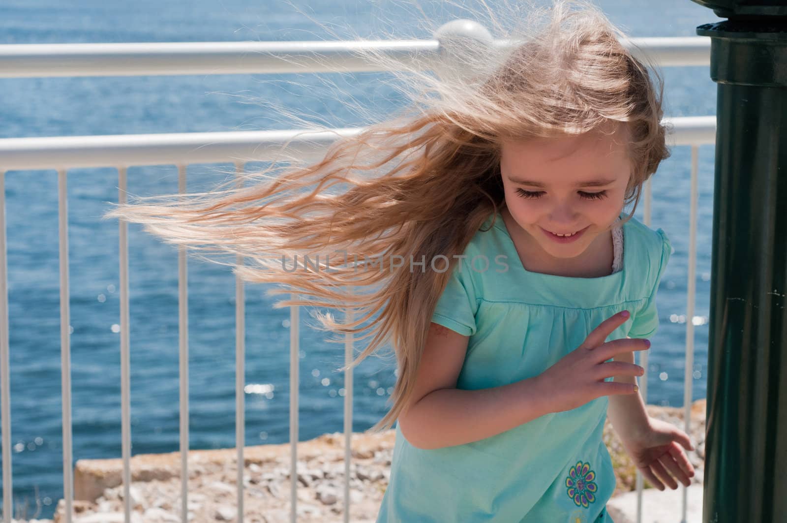 Little girl with long hair near blue sea