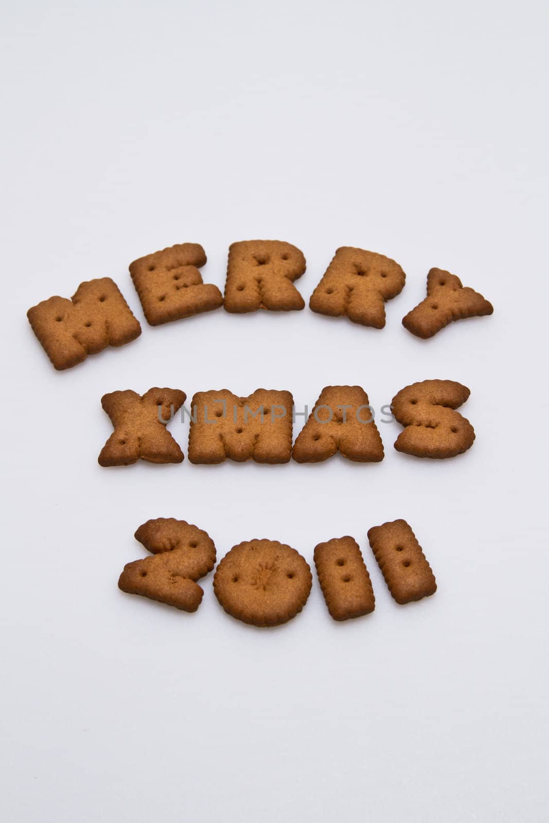 Merry Xmas 2011 wording from brown biscuits at center frame on white background  in portrait orientation