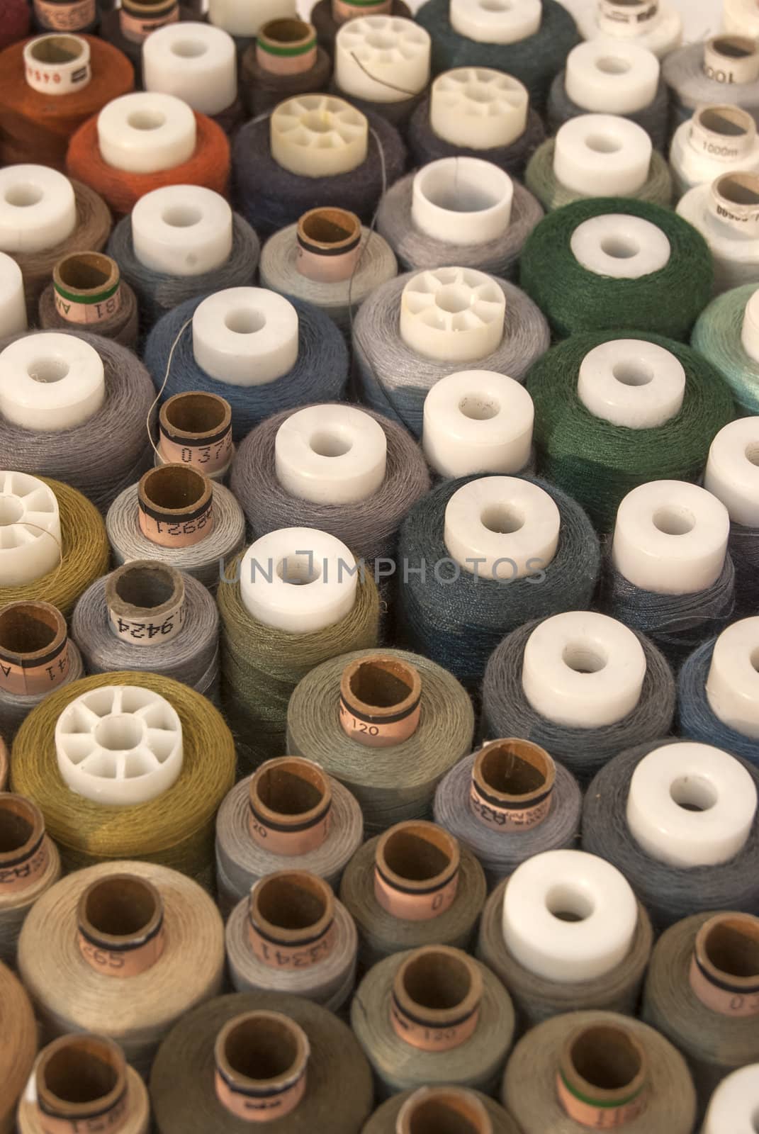 Different colored threads reels from above view as background
