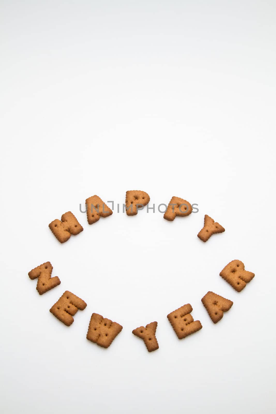 Happy New Year greeting words made by brown biscuits in lower center of white surface in portrait orientation for background use
