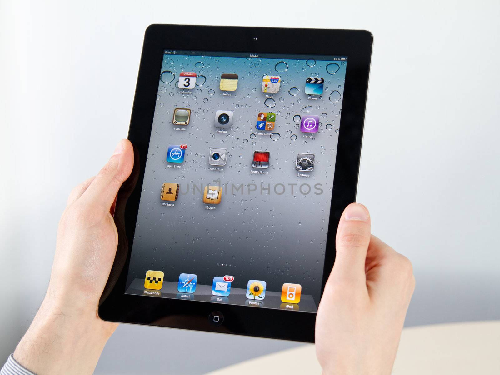 Kiev, Ukraine - December 03, 2011 - Man hands holding Apple iPad2 with homepage on a screen. This second generation iPad2 is designed and development by Apple inc. and launched in march 2011.