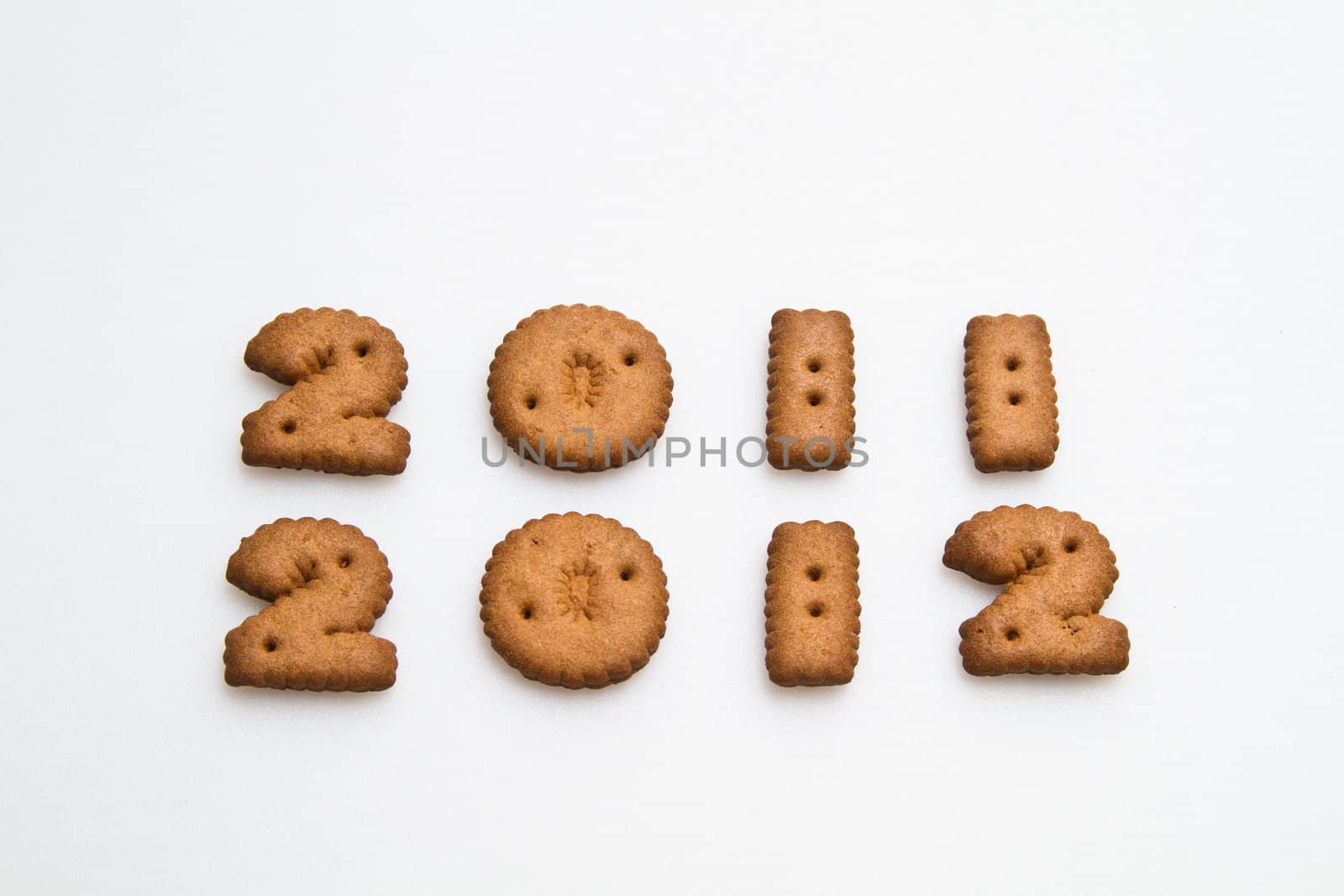 2011 and 2012 number made by brown biscuits on white surface in landscape orientation for background use