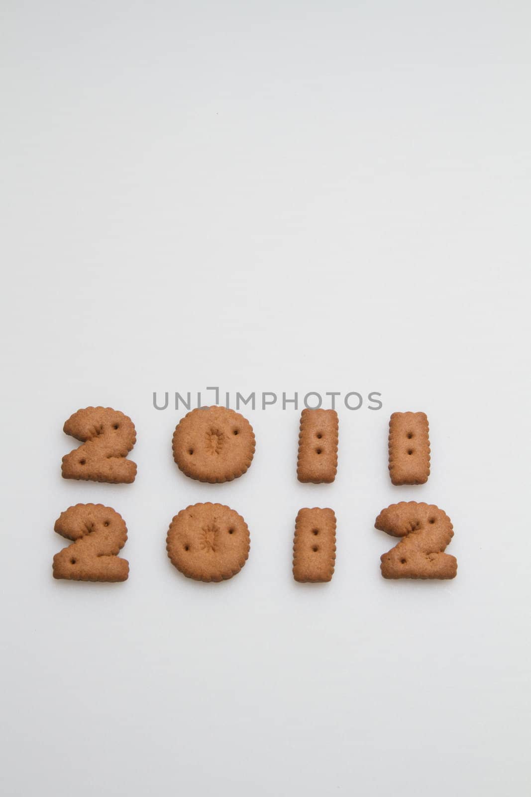 2011 and 2012 numbers made by brown biscuits in lower center of white surface in portrait orientation for background use