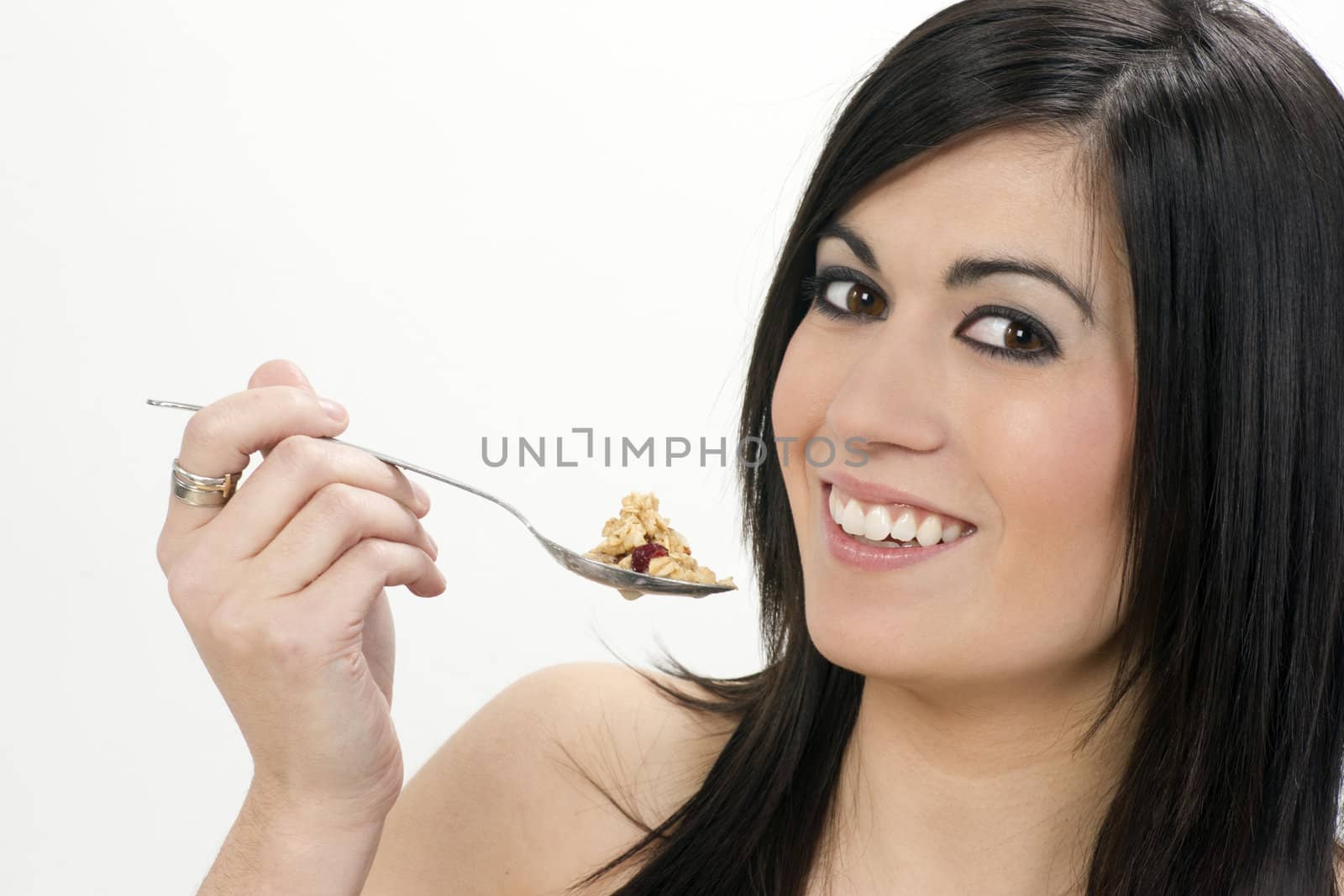 A horizontal composition of a woman eating cereal