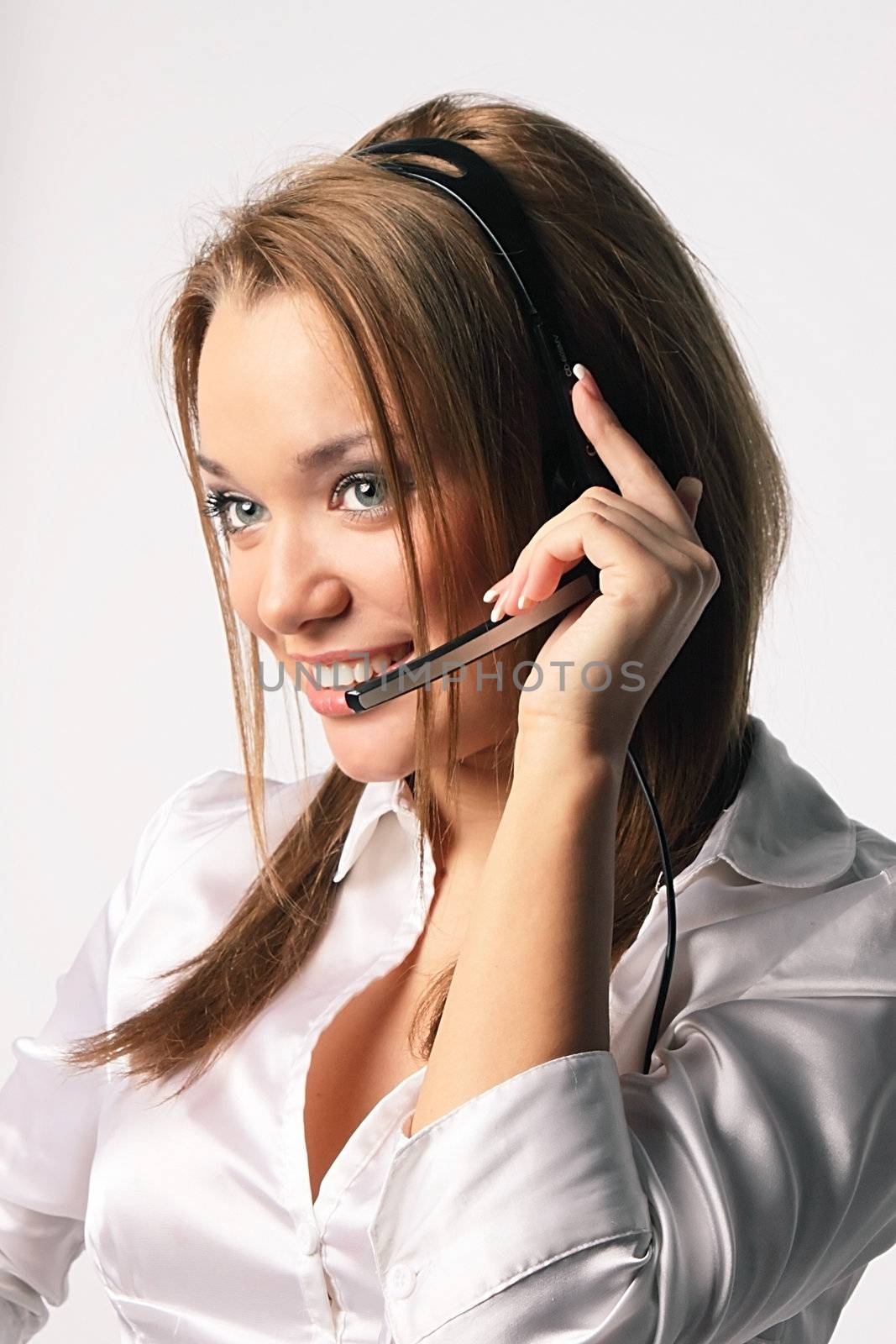 The young and beautiful girl from a support service with ear-phones and a microphone on a head