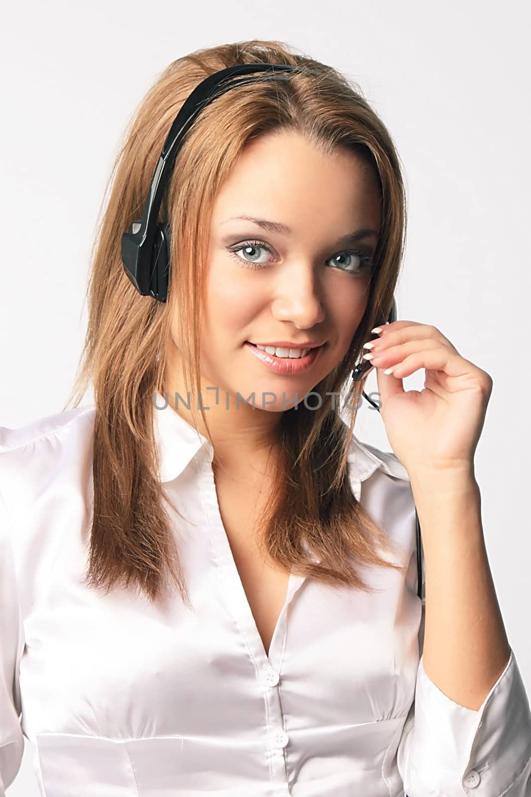 The young and beautiful girl from a support service with ear-phones and a microphone on a head