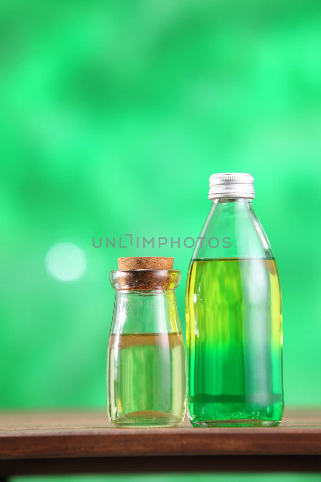 Bottle with massage oil on the green background