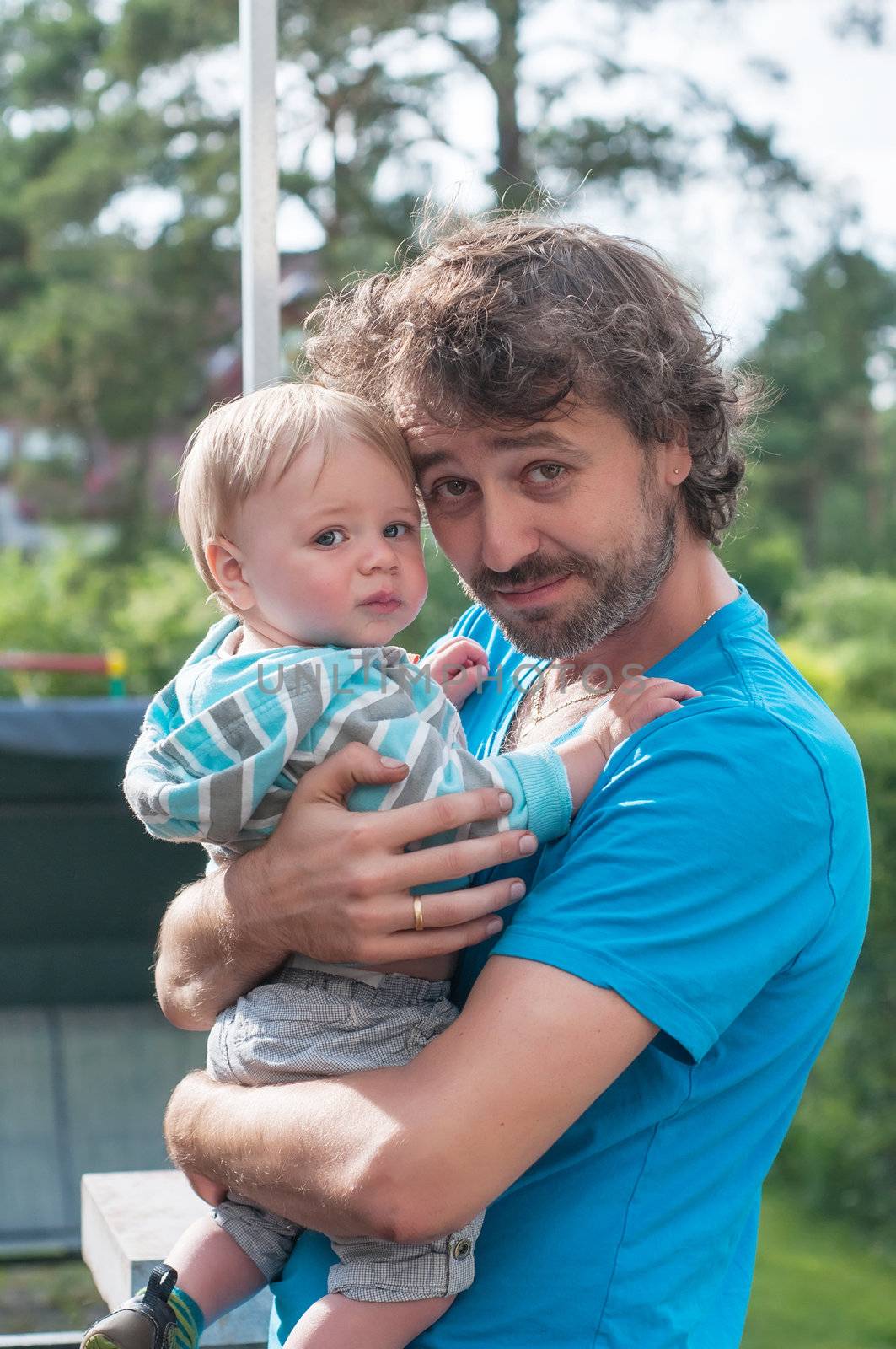 Father carrying son on his hands, outside