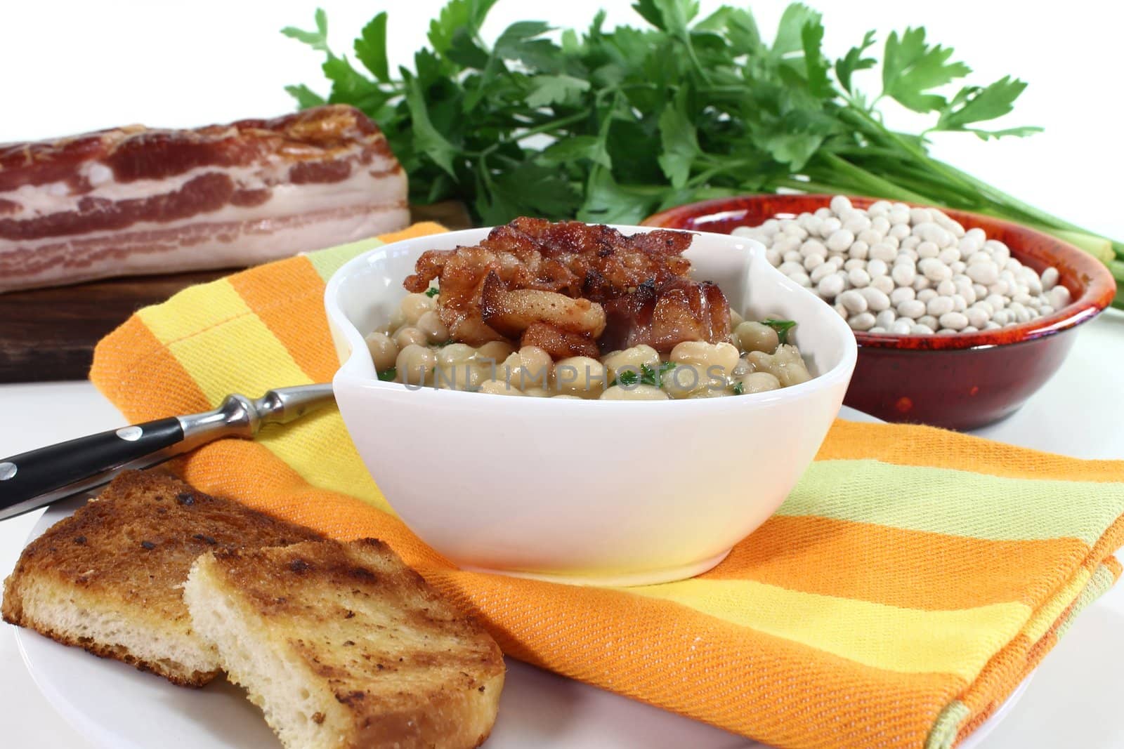 a bowl of white beans and fried bacon