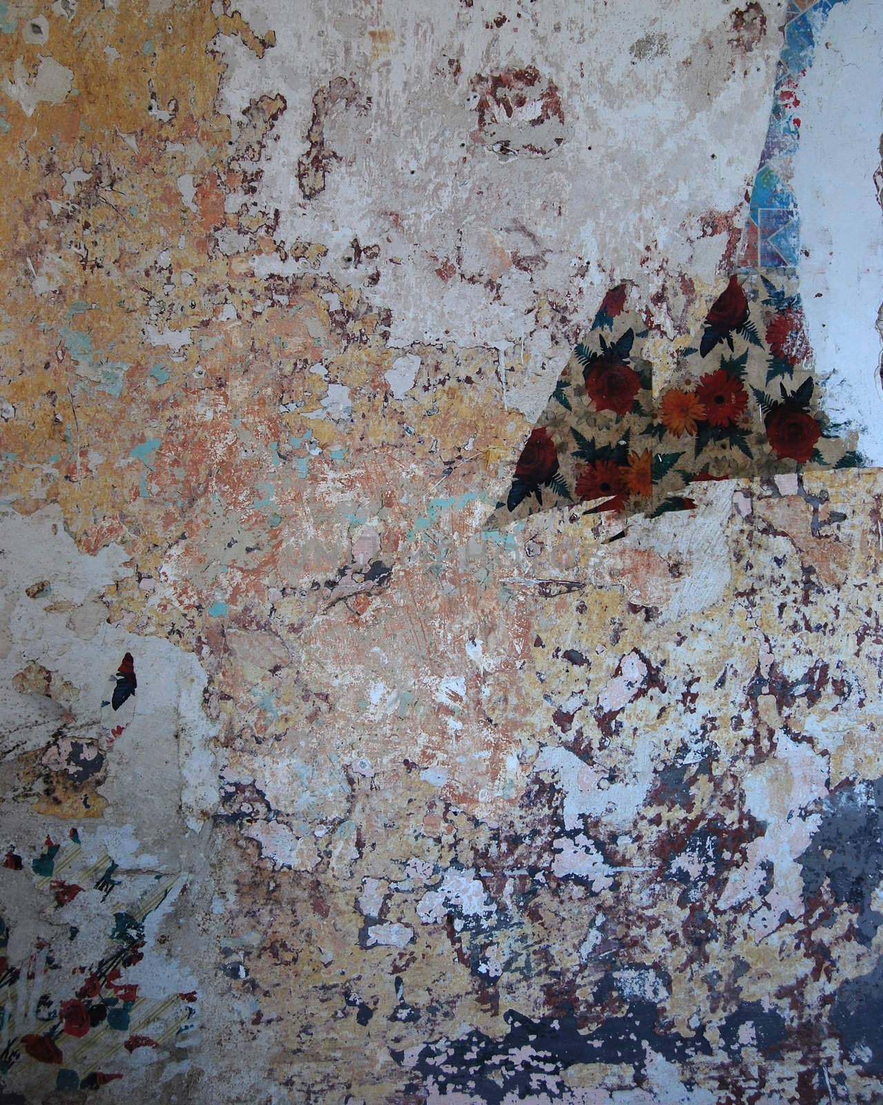 Grungy room wall with old coats of paint and wallpaper