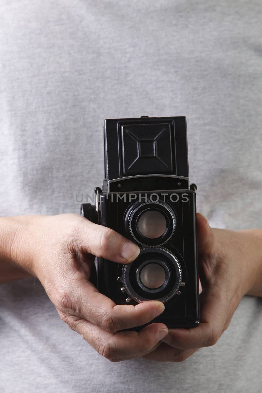 stock image of the unrecognisable people holding a antique camera
