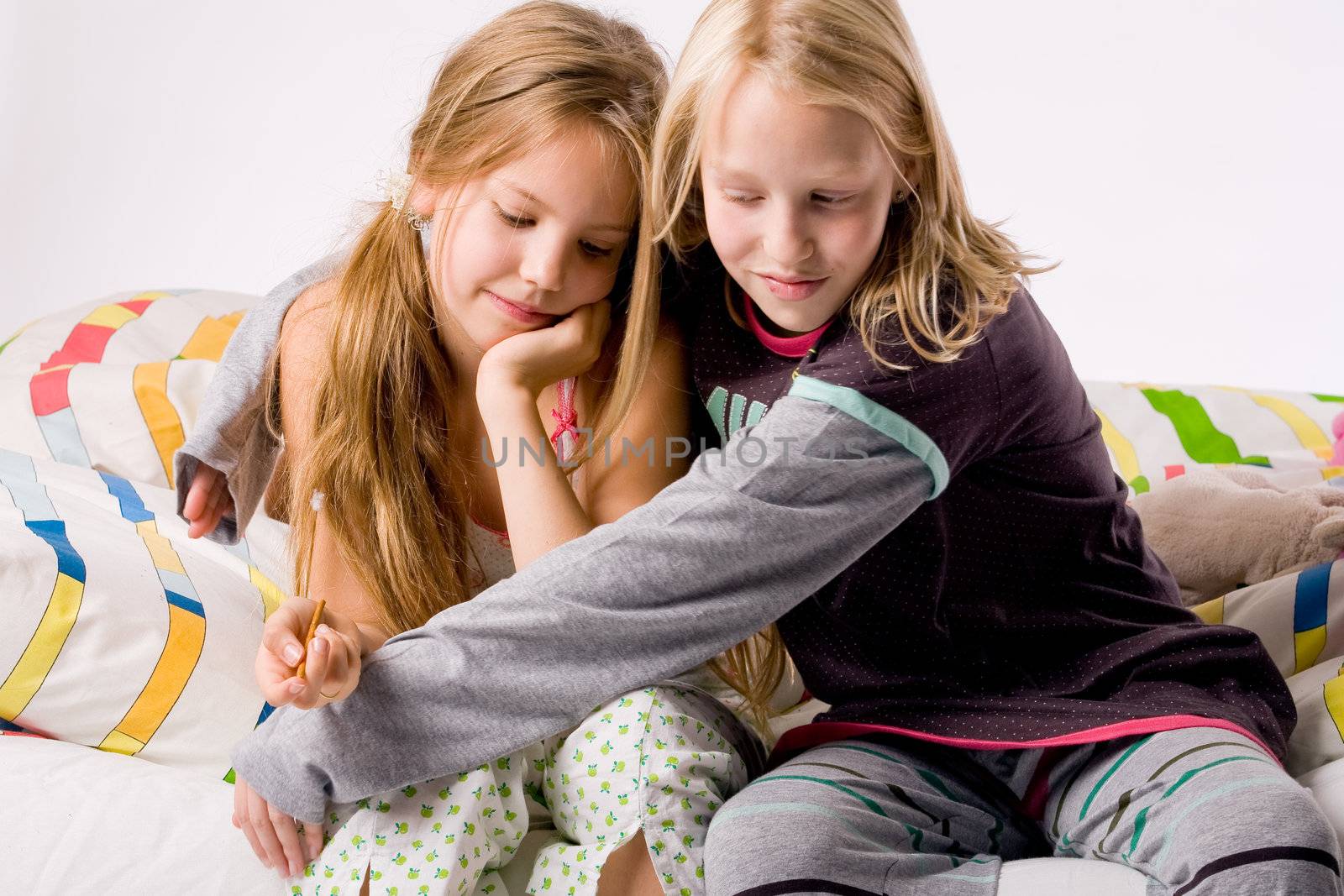 Two young children enjoying their colorful bed