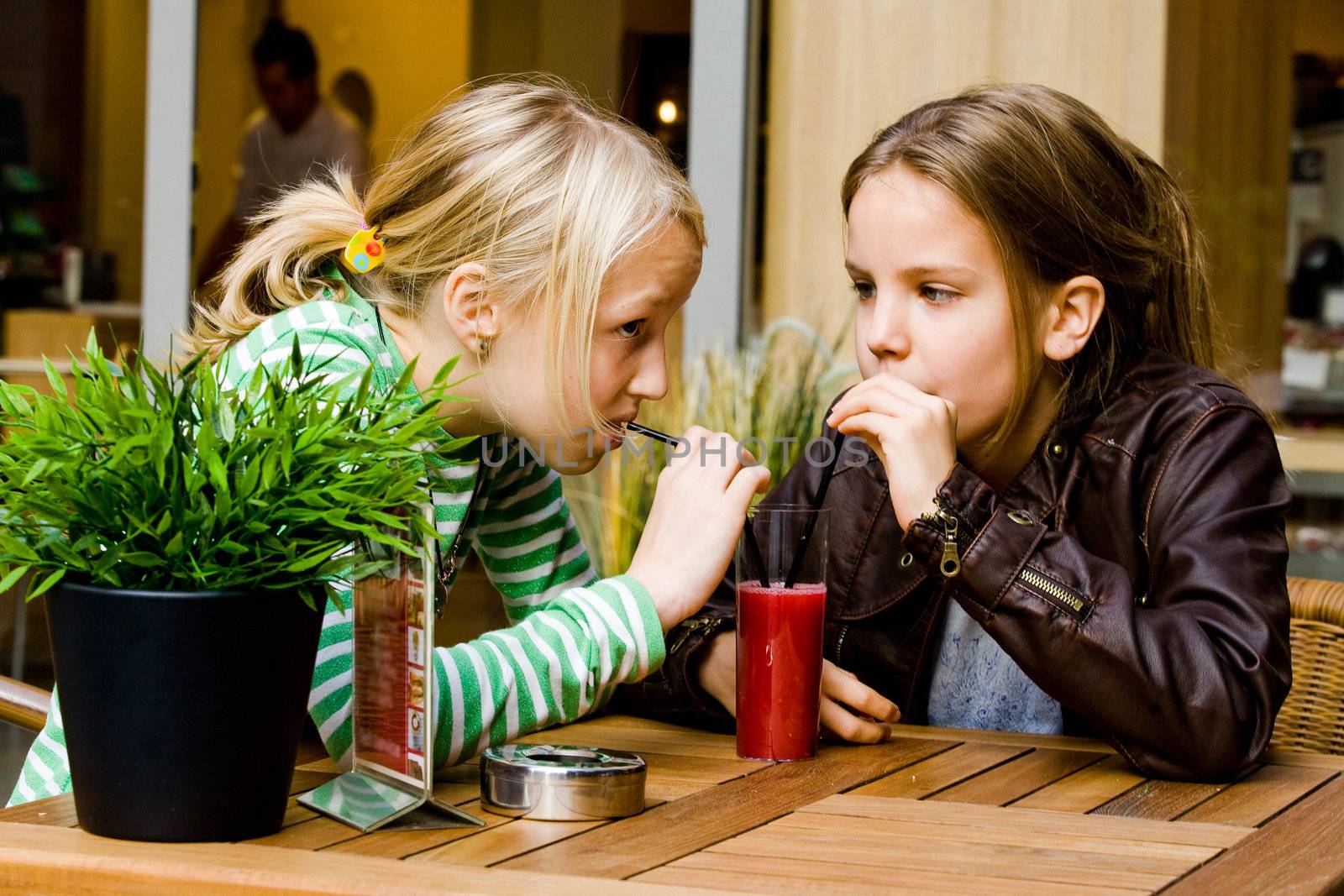 Two cute children having a drink toghether