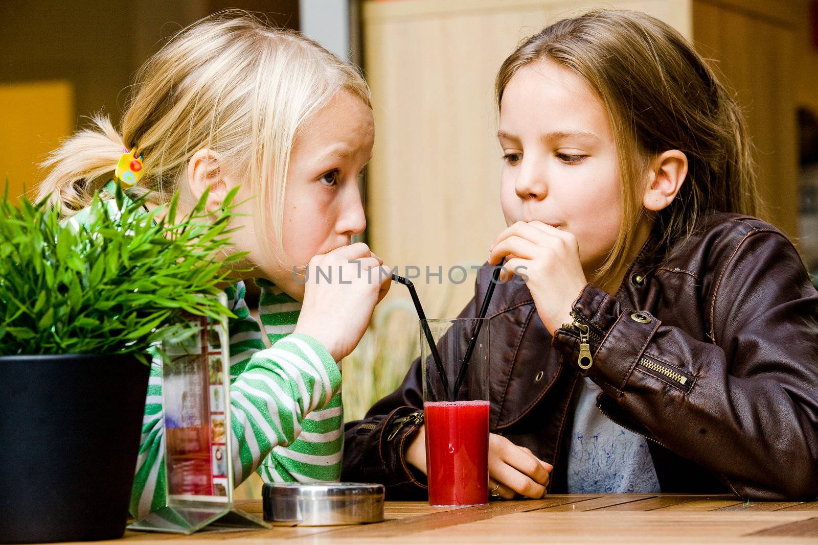 Two cute children having a drink toghether