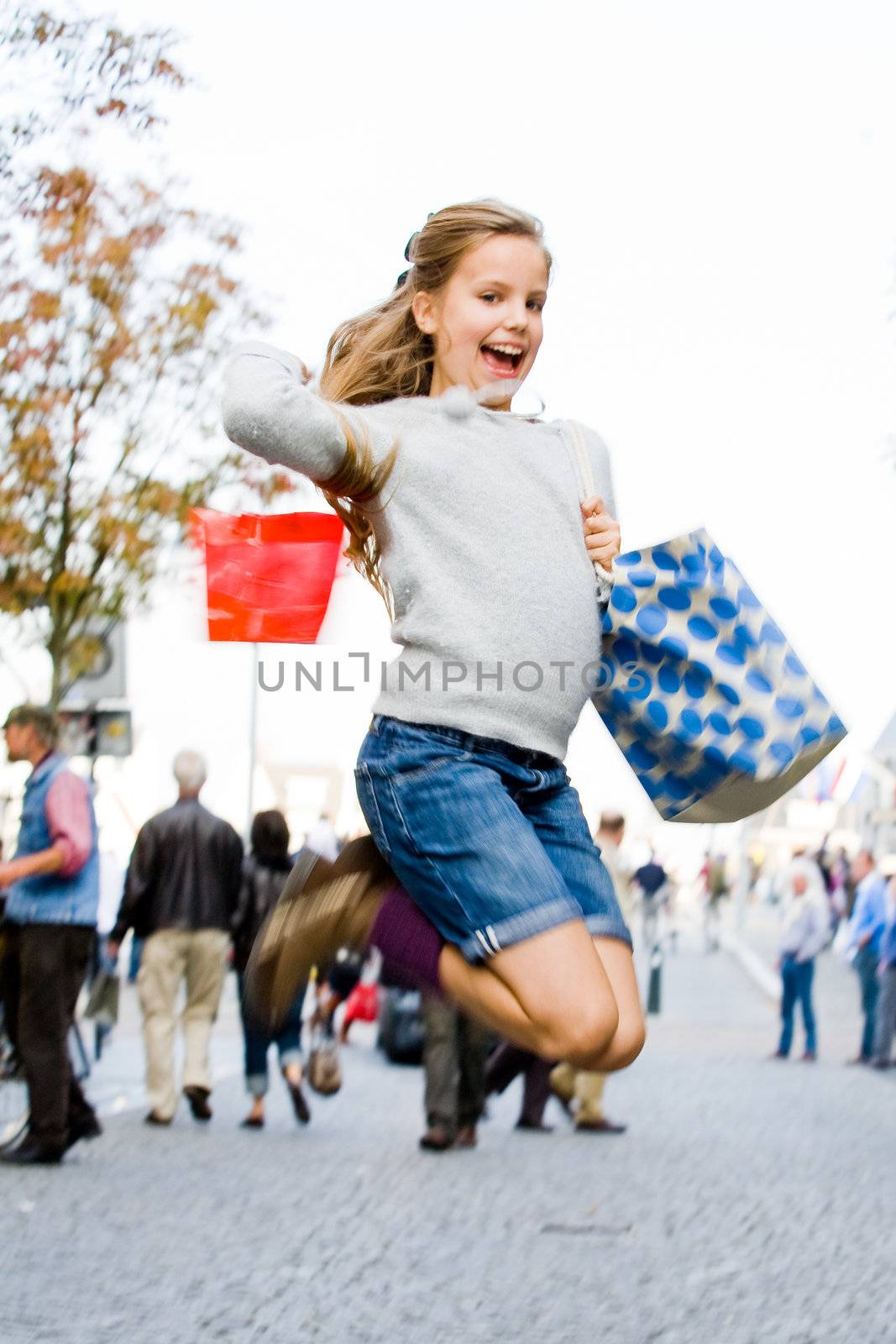 Young cute girl is jumping while shopping