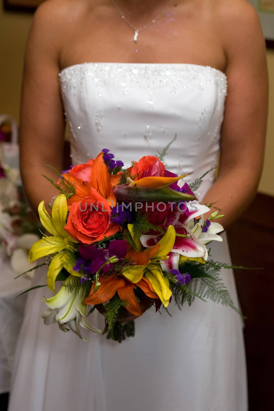 A bride in a white wedding dress holds her bridal bouquet.