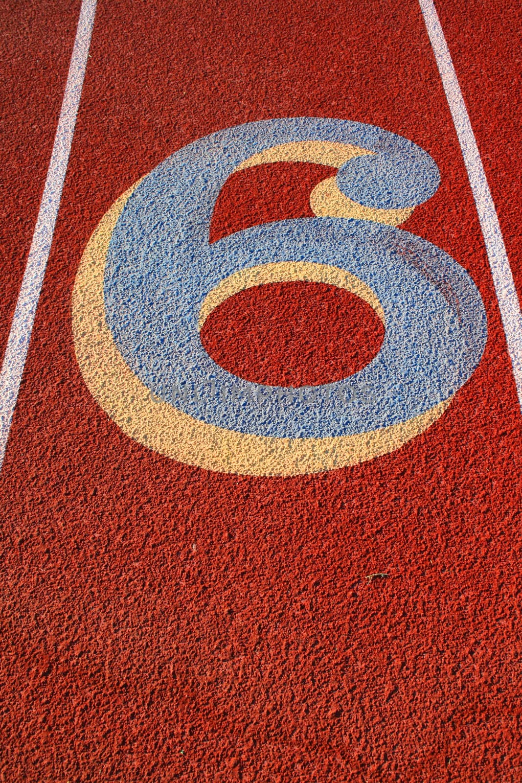 Close up of a number six on a running lane.
