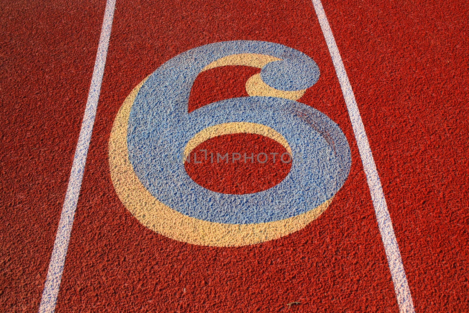 Close up of a number six on a running lane.
