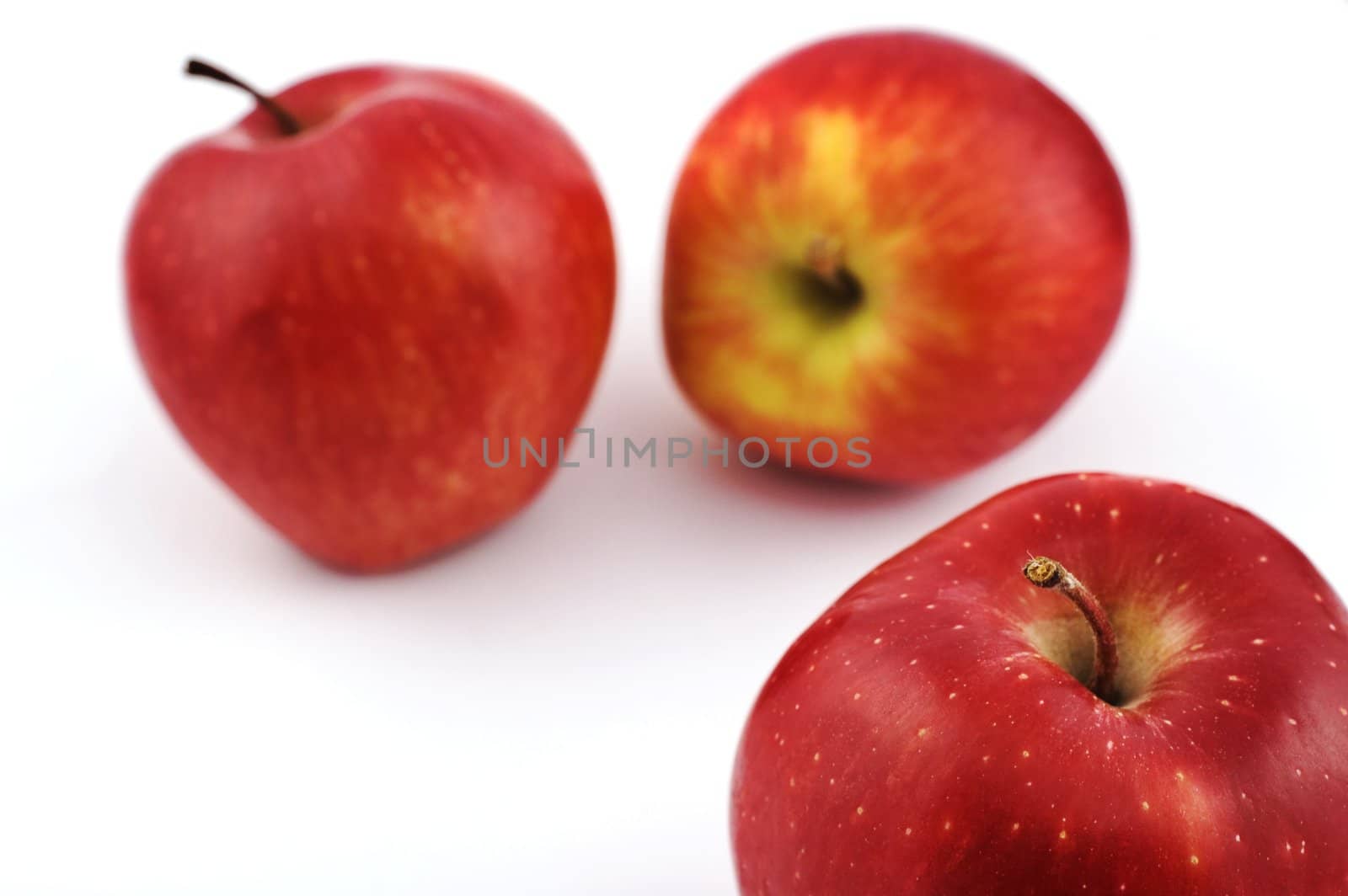 Three apples on white background with shallow depth of field