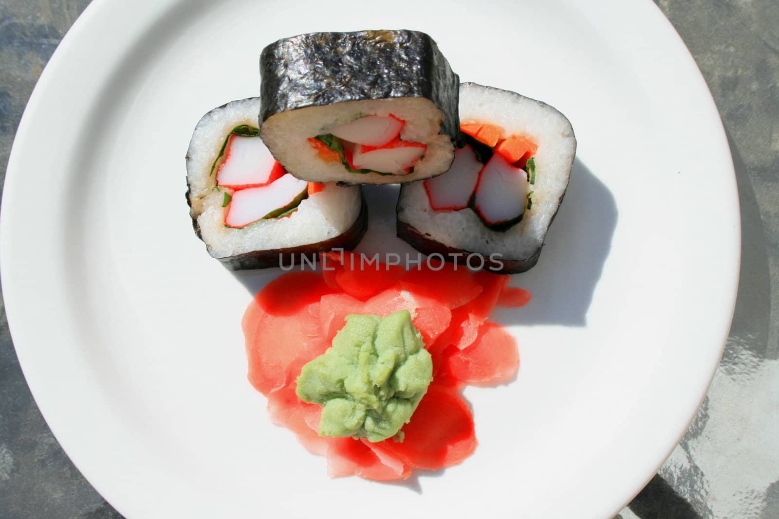 Sushi next to wasabi and sushi ginger on a platter.
