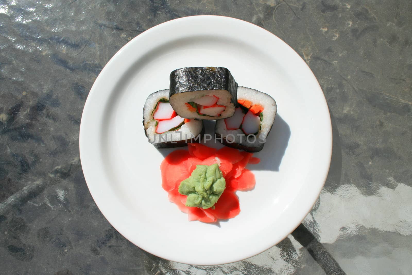 Sushi next to wasabi and sushi ginger on a platter.
