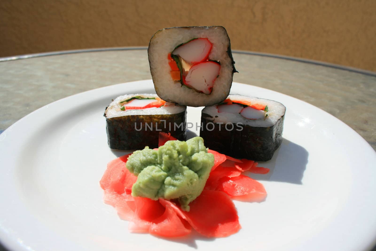 Sushi next to wasabi and sushi ginger on a platter.
