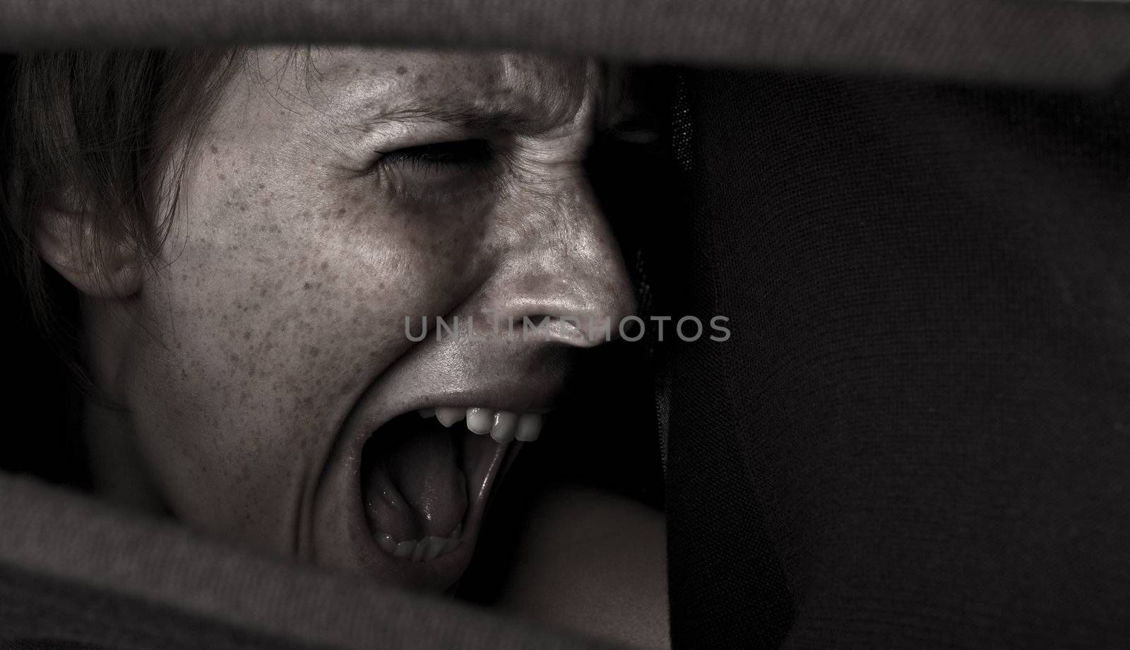 Studio portrait of a cute and beautifull girl in a turtle neck sweater screaming