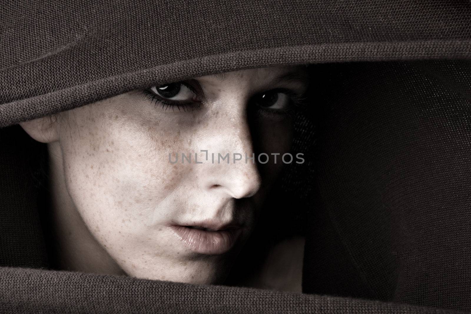 Studio portrait of a cute and beautifull girl in a turtle neck sweater looking questionable