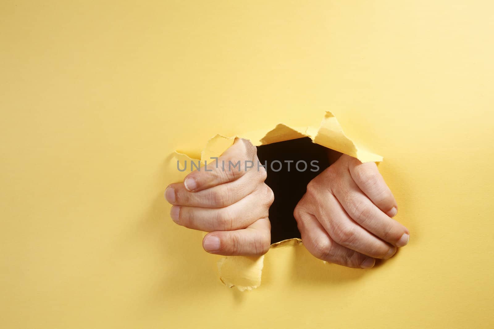 stock image of the hands breaking through a hole