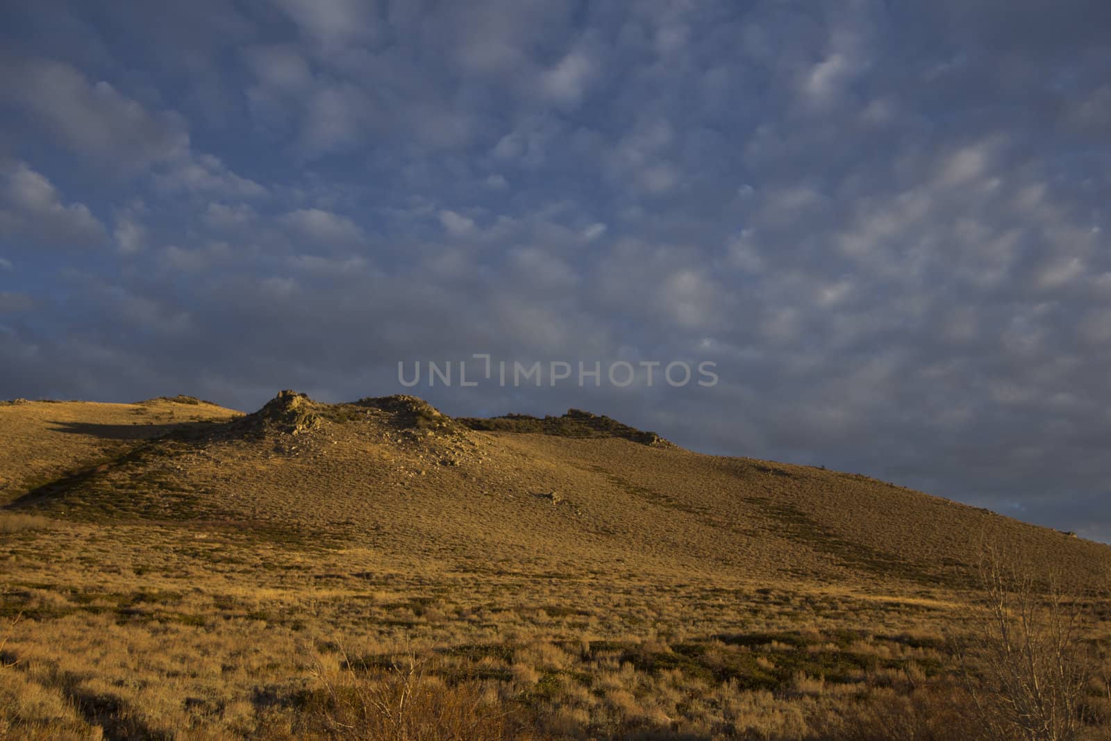 High desert sunset mountain with clouds by jeremywhat