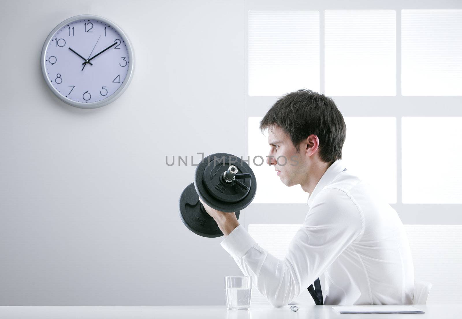 Young business man is training with dumbbells