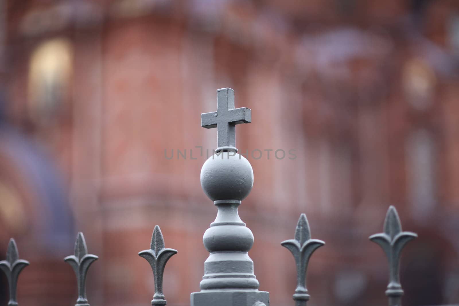 small cross on iron fence