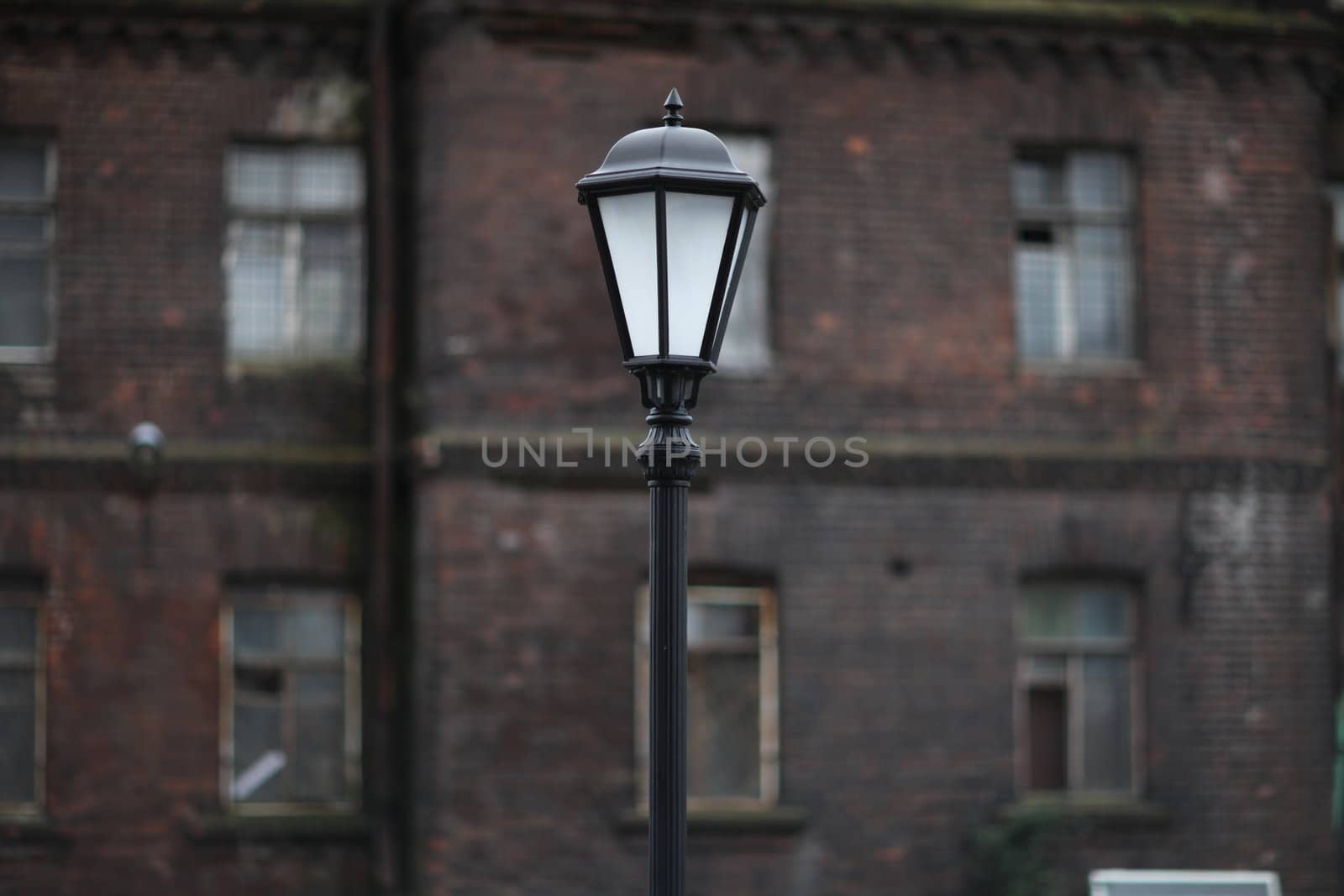 Lamppost on the background of an old brick building