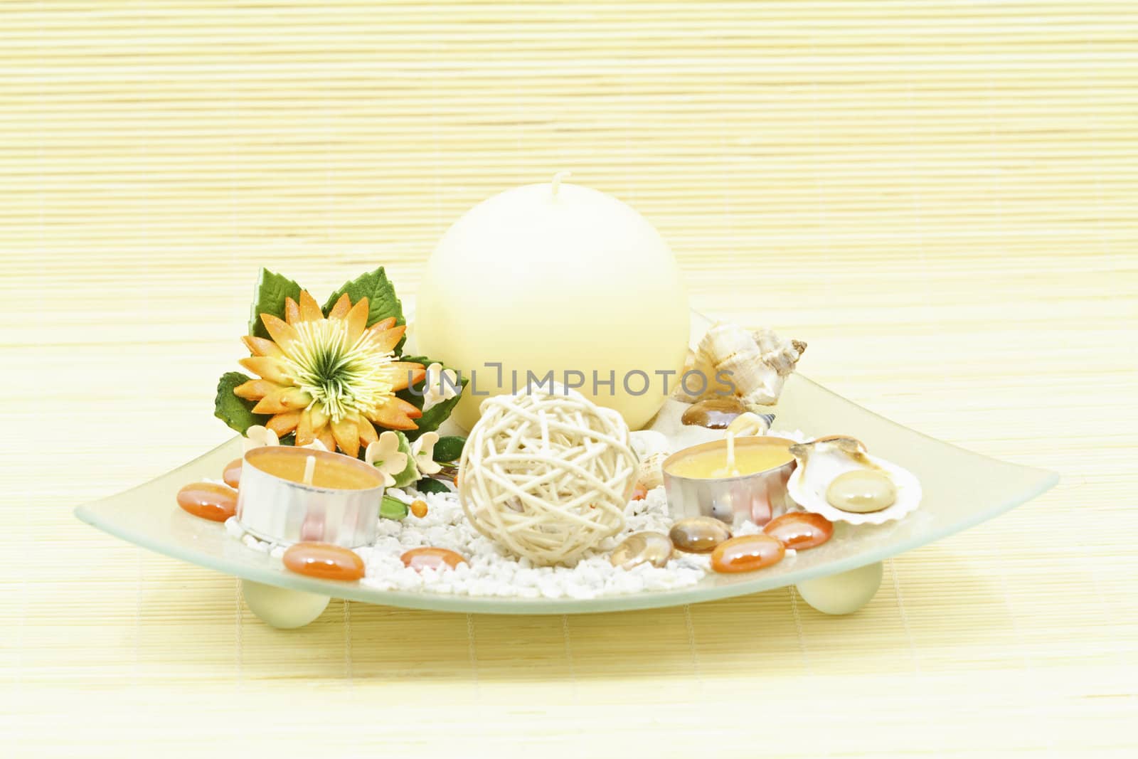 Home decoration with candle and artificial flower on decorative glass plate